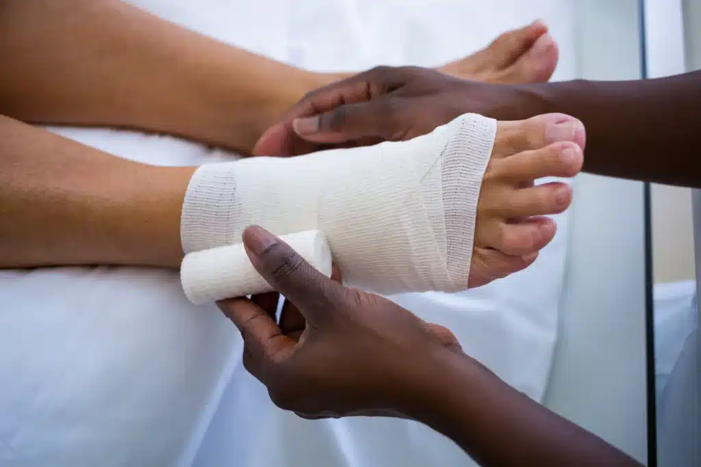 Dr. bandaging patient foot