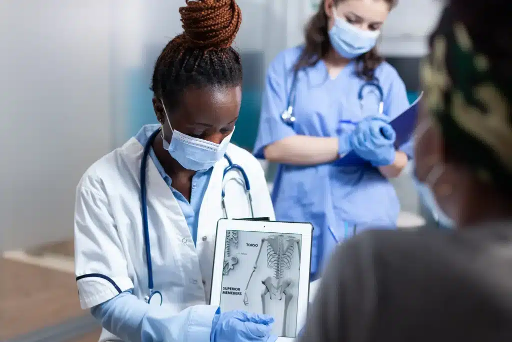 Orthopaedic doctor showing skeleton on tablet