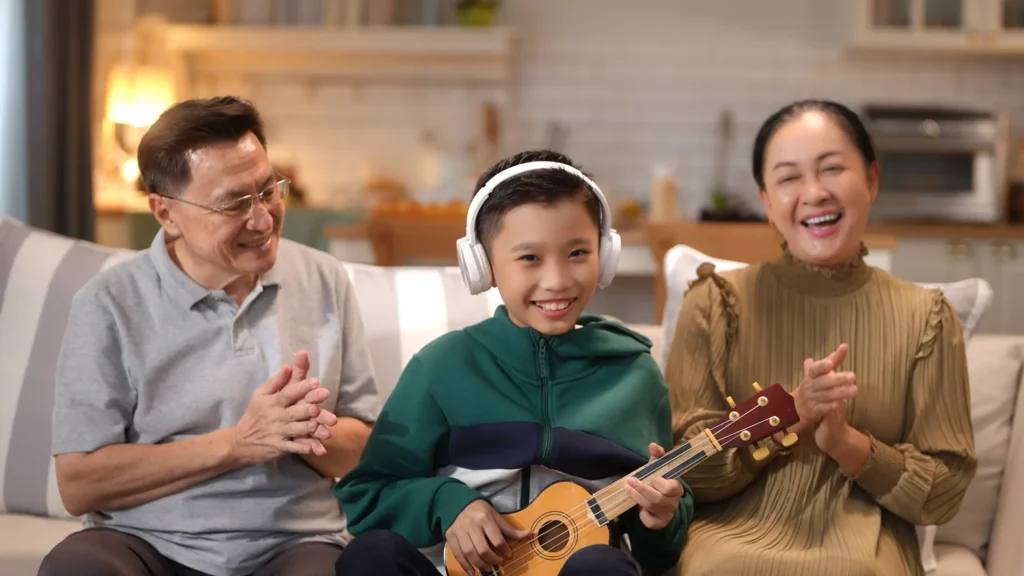 Happy family with boy playing ukulele