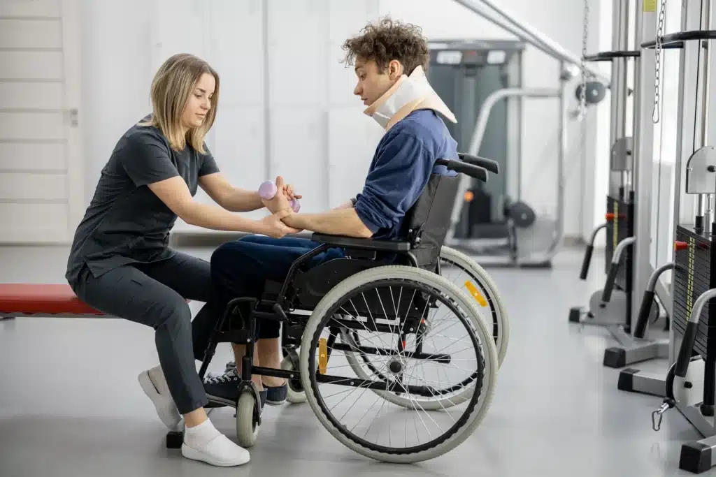 Rehab specialist with young man in wheelchair