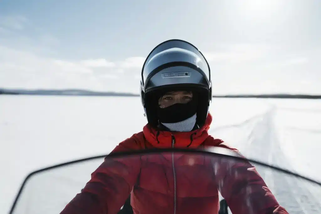 Woman driving snowmobile on lake