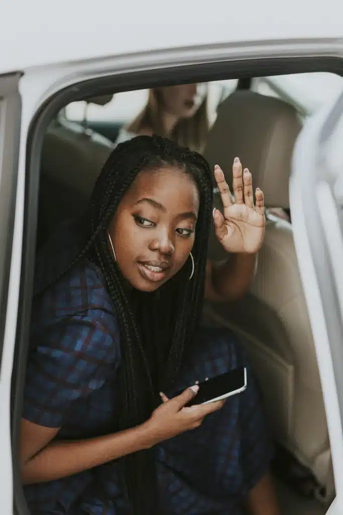 Young woman getting out of the back of a rideshare car